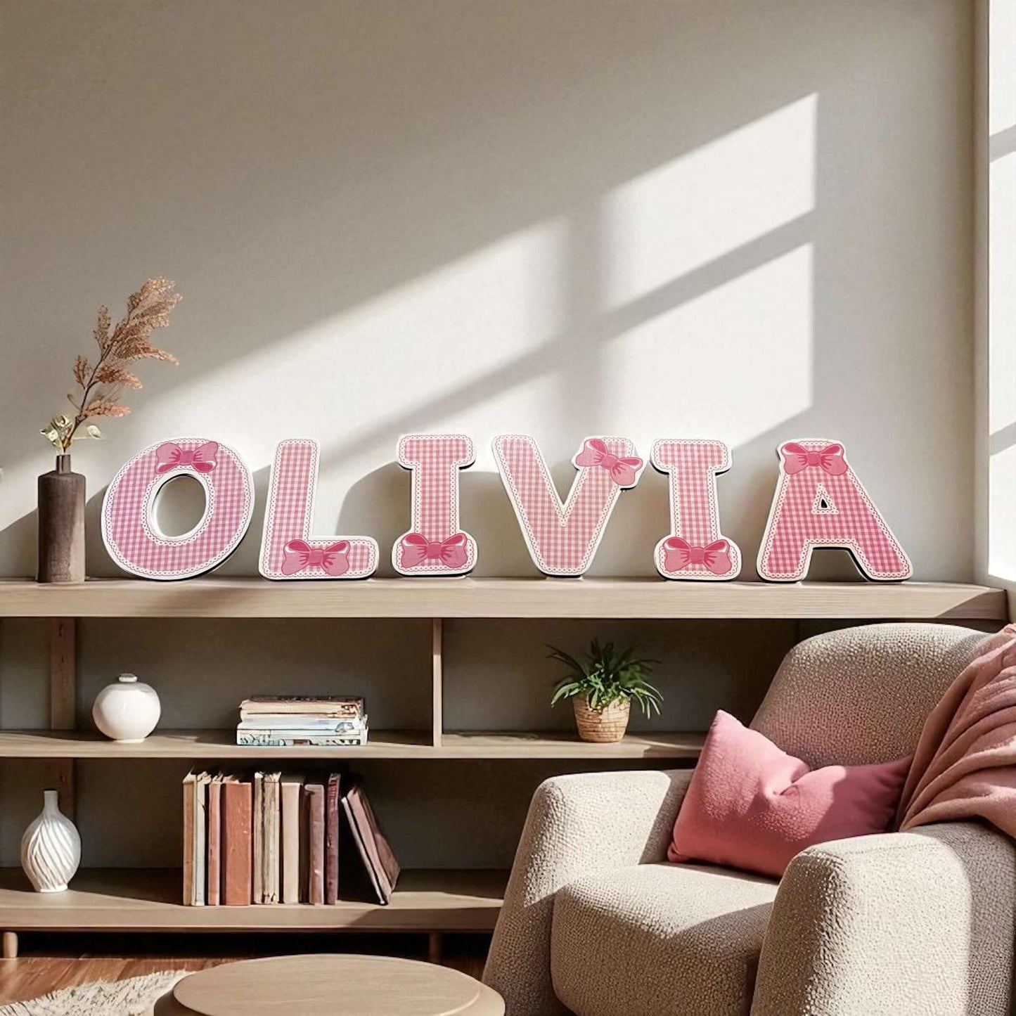Decorative name 'OLIVIA' on a shelf with a cozy living room setting.