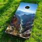 Cornhole Board - 120x60 cm with a scenic mountain landscape design on a grassy field.