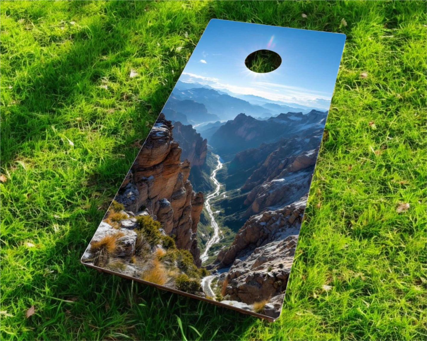 Cornhole Board - 120x60 cm with a scenic mountain landscape design on a grassy field.