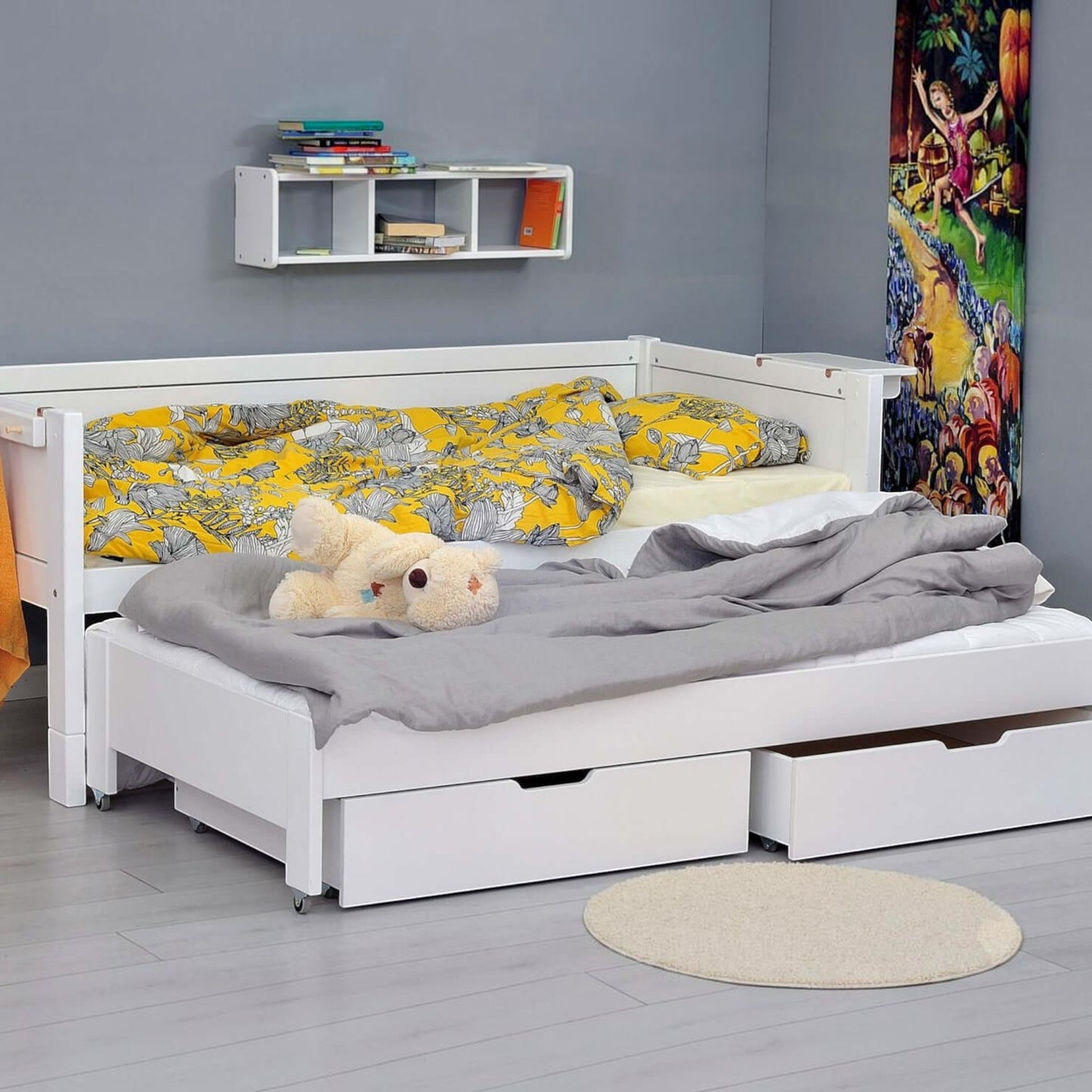 Infano Jerwen compact white birch wood bed with pull-out trundle, storage drawers, and yellow floral bedding.