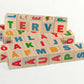 Wooden letter blocks - finnish alphabet - 30 pcs displayed in a colorful stack with Finnish letters and illustrations.