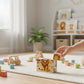Wooden Puzzle Cubes – Savanna Adventures with a child stacking lion block in a cozy playroom.